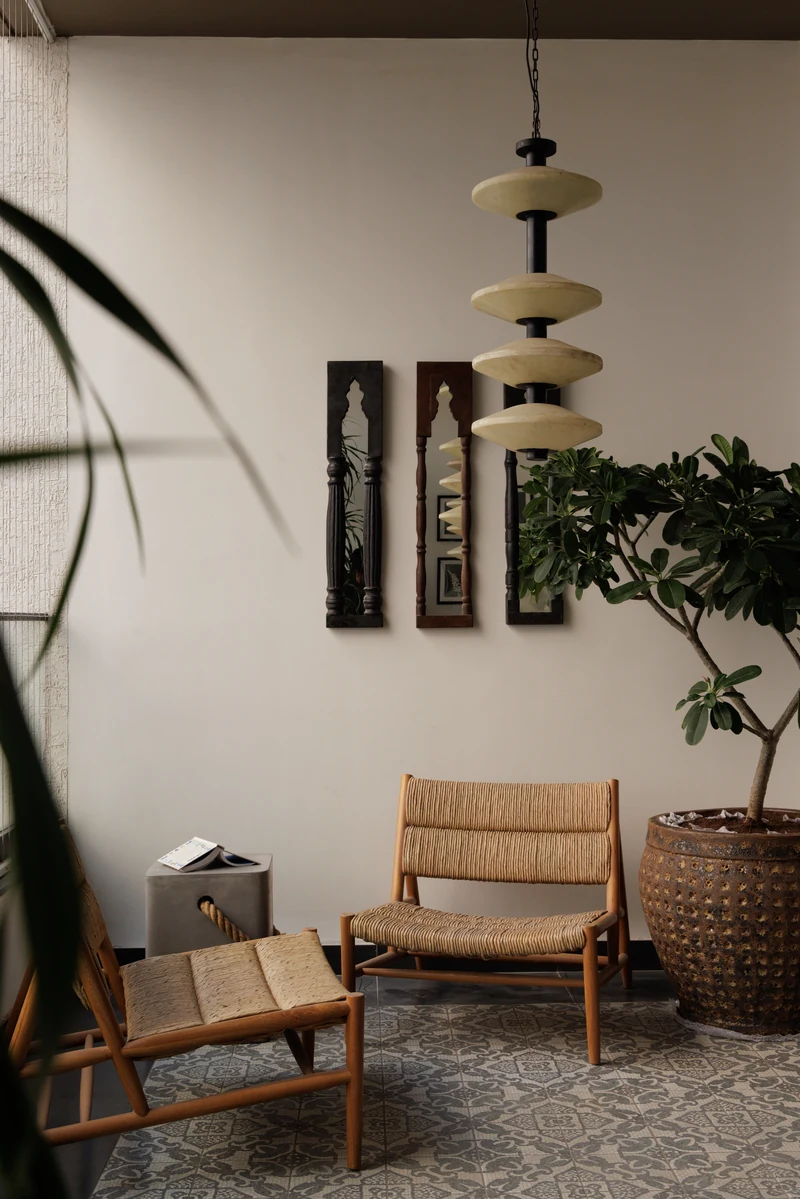 A woven chair beneath a stacked pendant, Aparna One